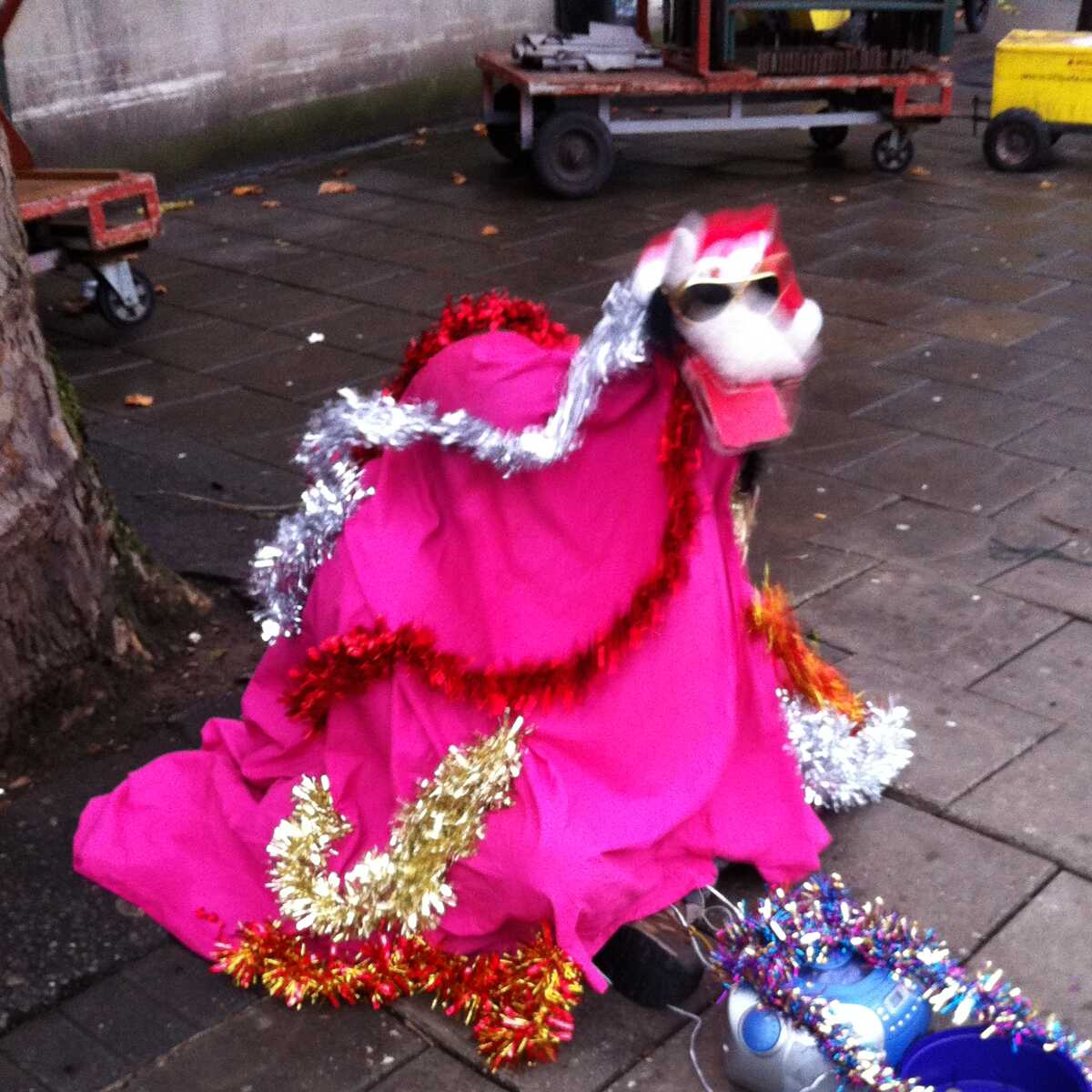 A street performer dressed as a pink dog with a clapping jaw